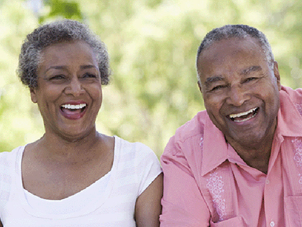 Active and happy senior couple smiling while one a bike ride outdoors