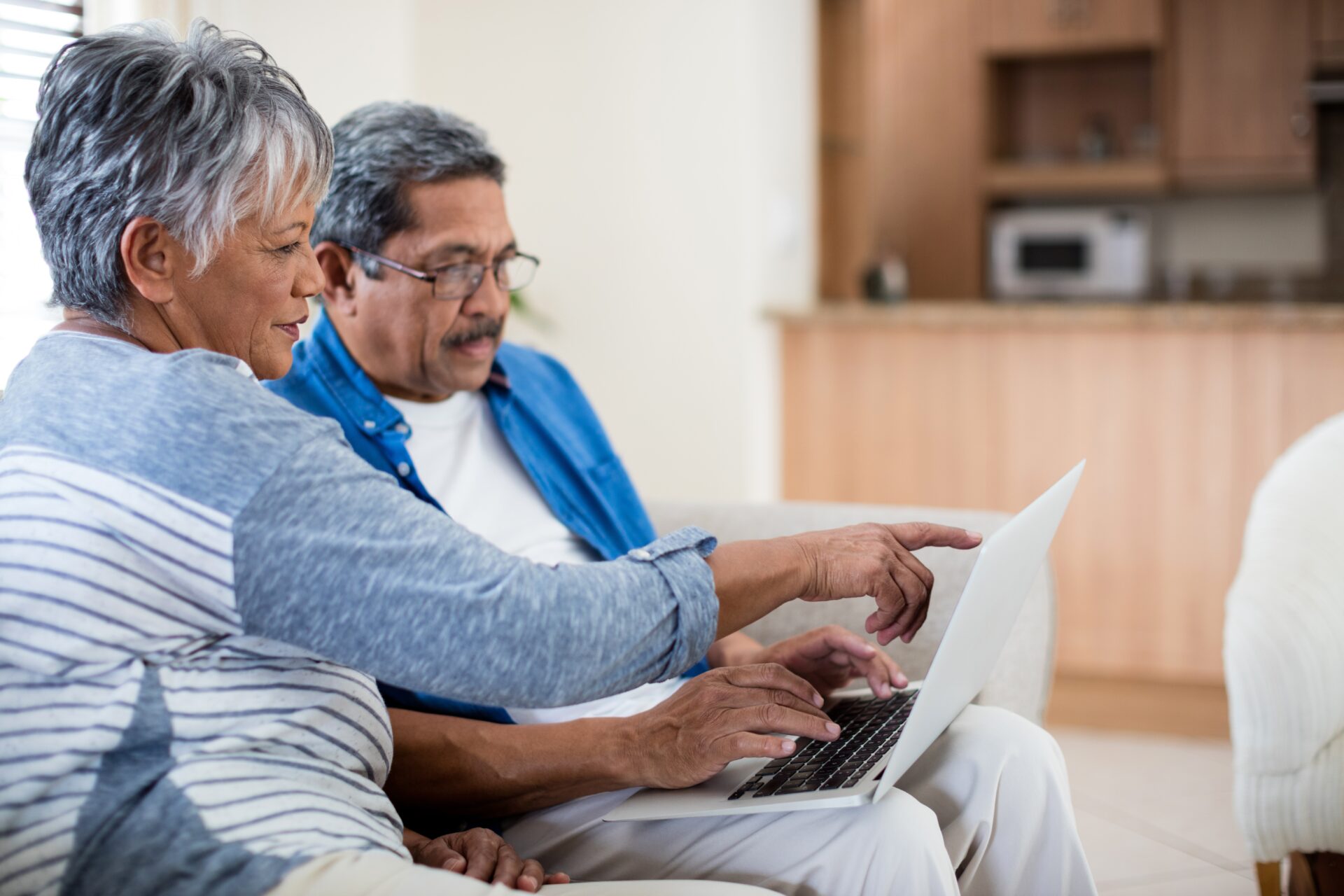 Senior man and woman reviewing information on a laptop.