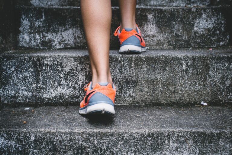 Picture of legs of person exercising by running up steps wearing running shoes