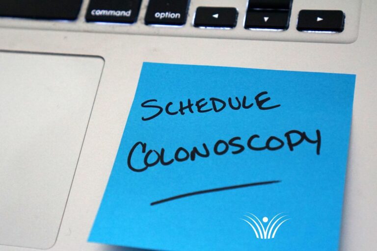 Blue post-it note reminder to schedule a colonoscopy